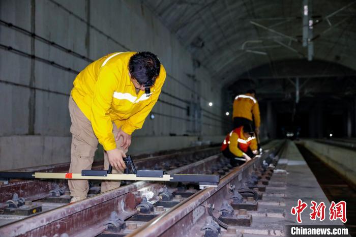 中國鐵路南寧局集團(tuán)有限公司南寧工務(wù)段職工使用道尺檢查吳圩機(jī)場高鐵站高鐵線路設(shè)備?！№f剛 攝